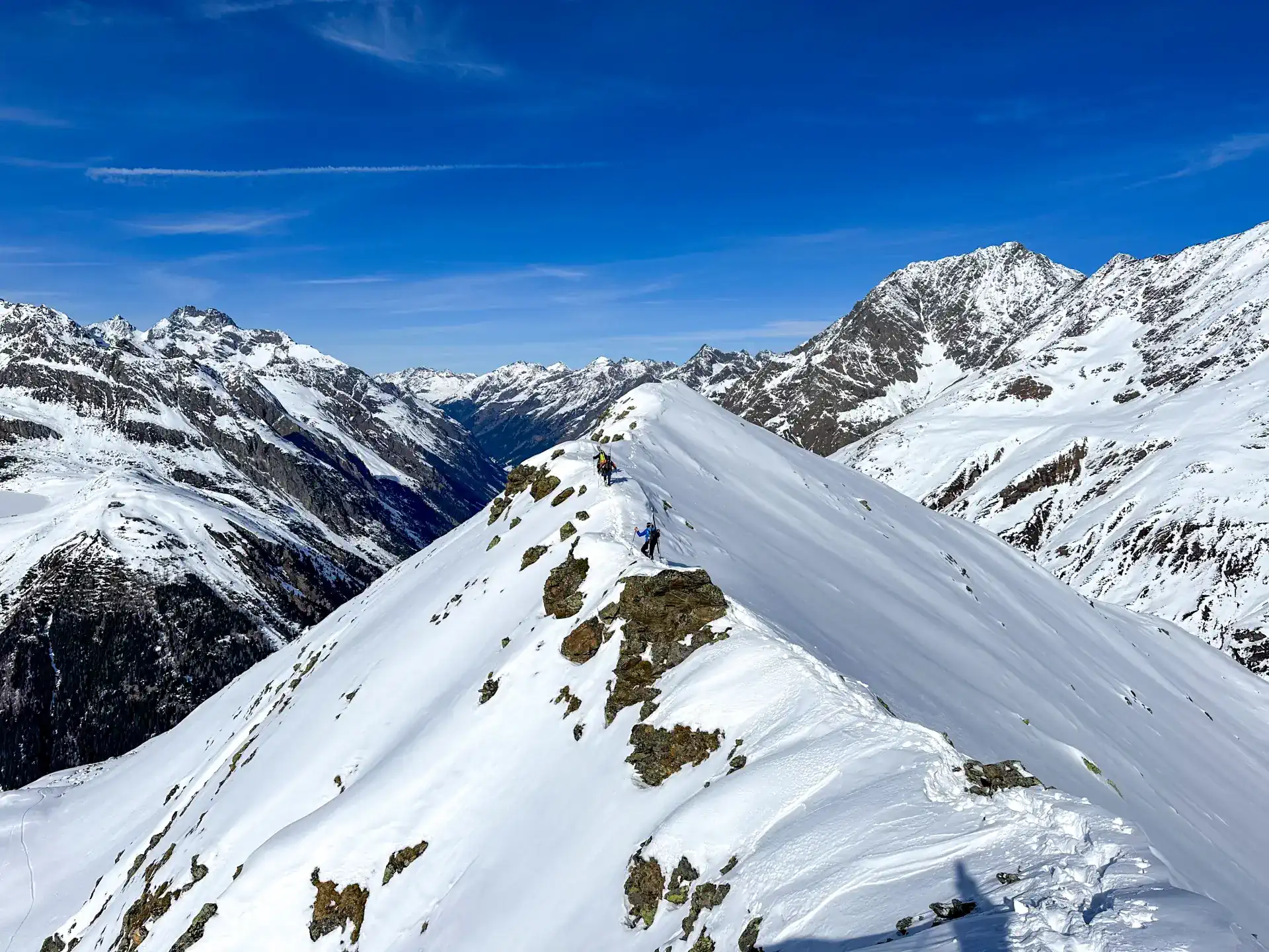 Freeride trägt Ski am Grat